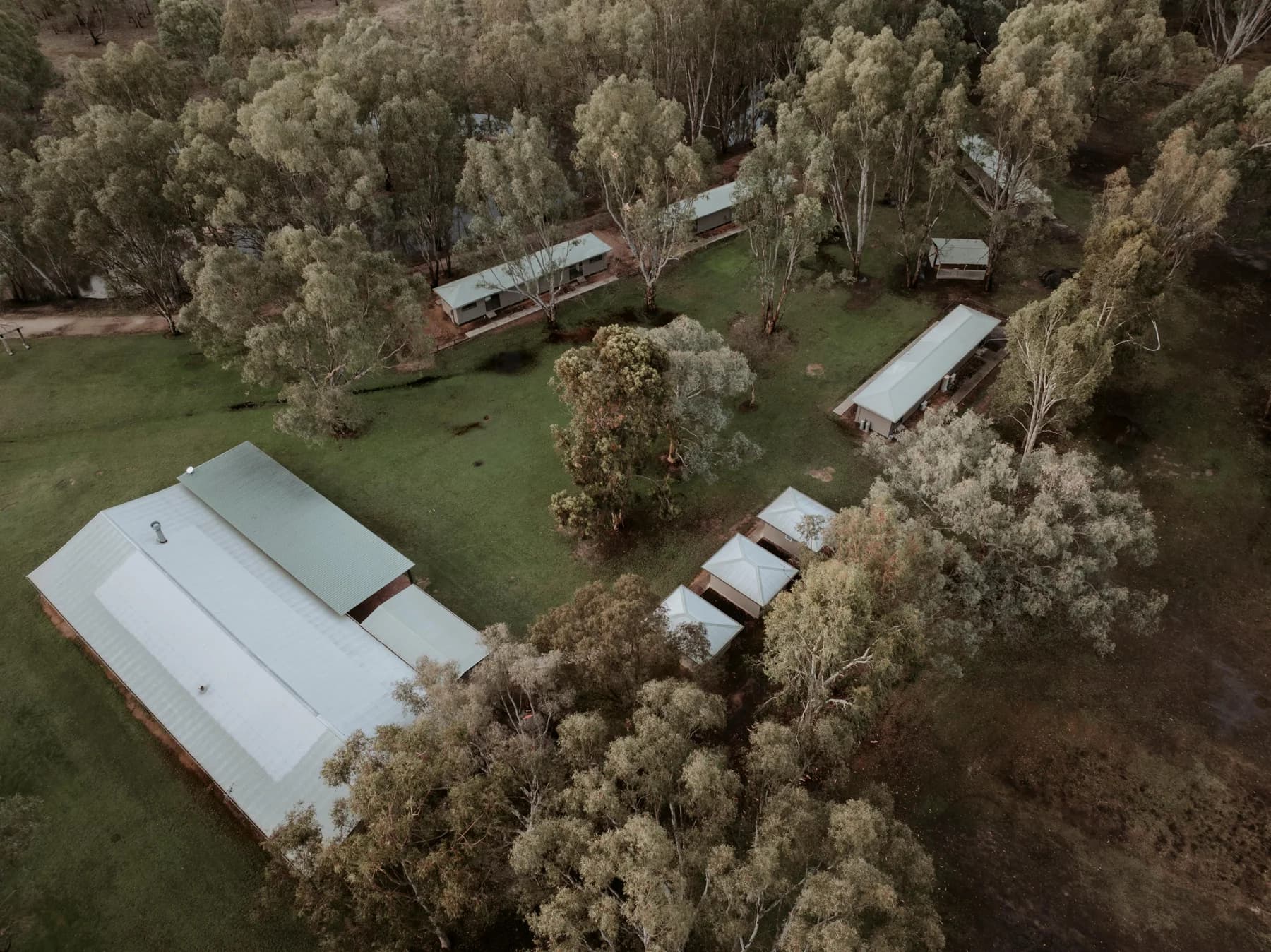 Aerial photograph showing the reception building, cabins and trees at The Paddock
