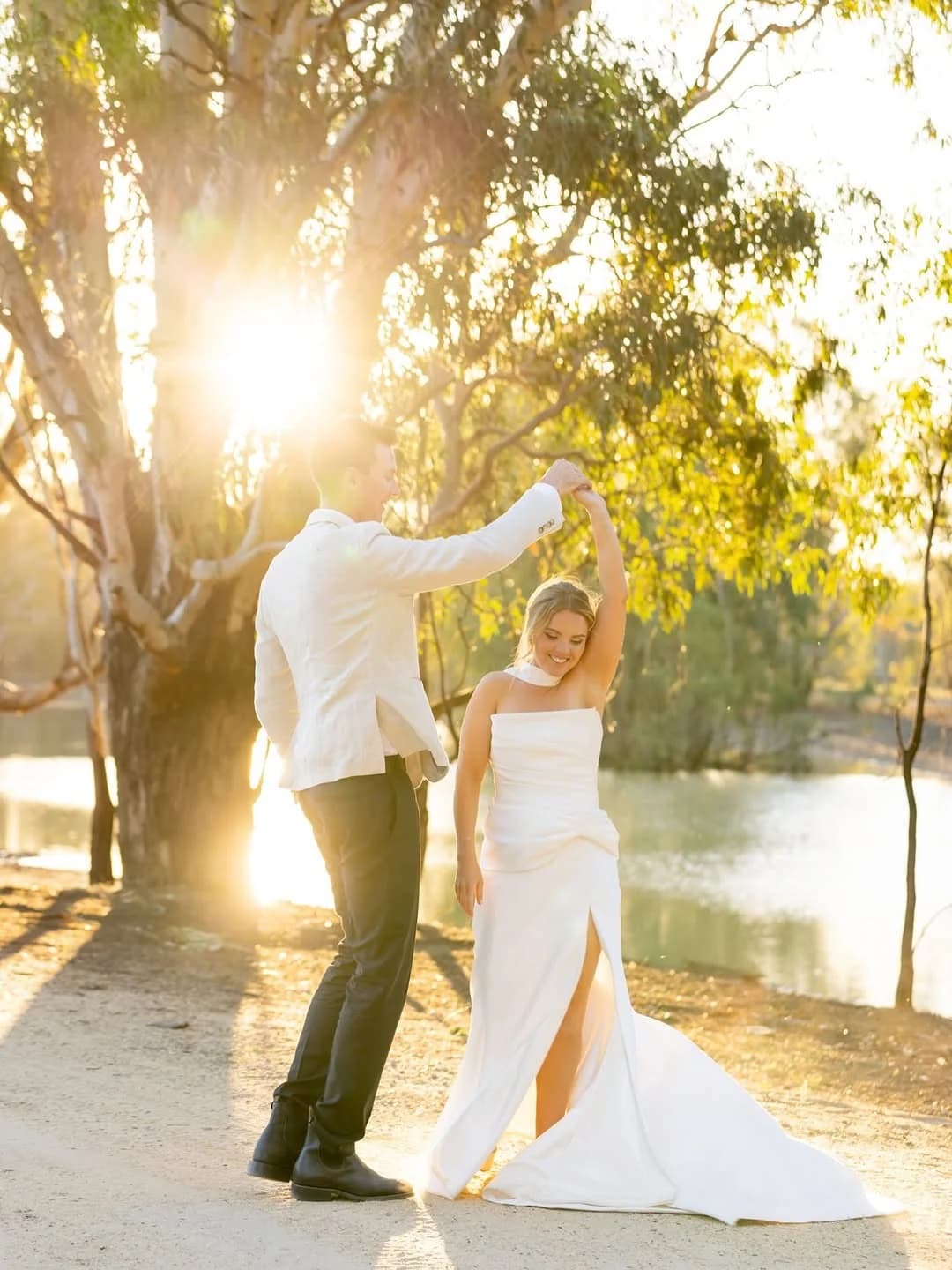 A wedding couple beside the lagoon at The Paddock in golden evening light