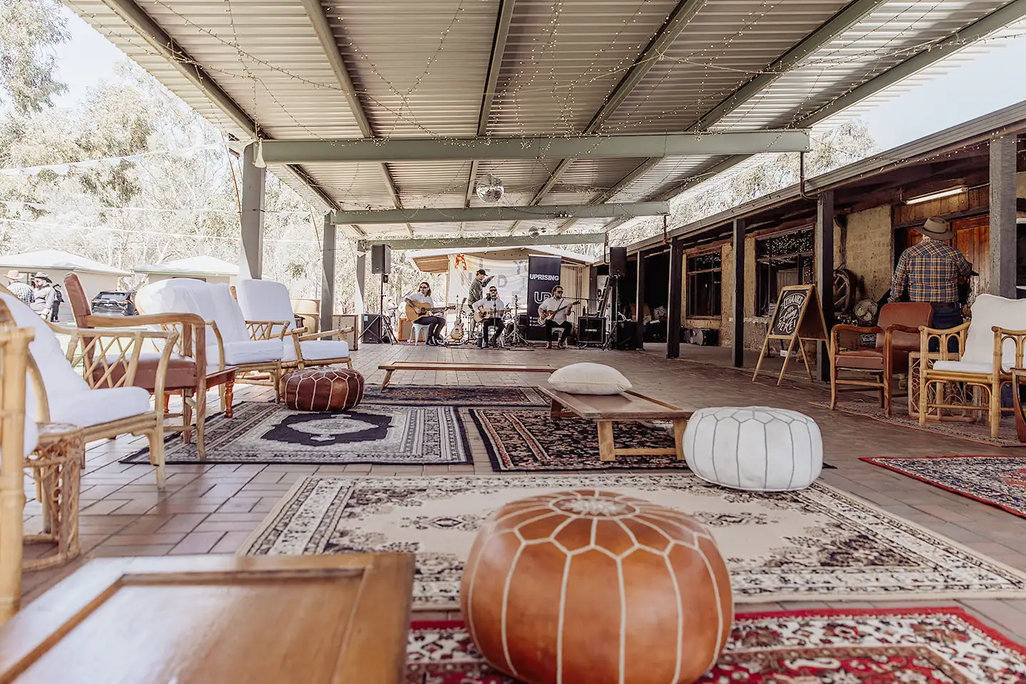 A covered lounge and music setup beside the mud-brick venue